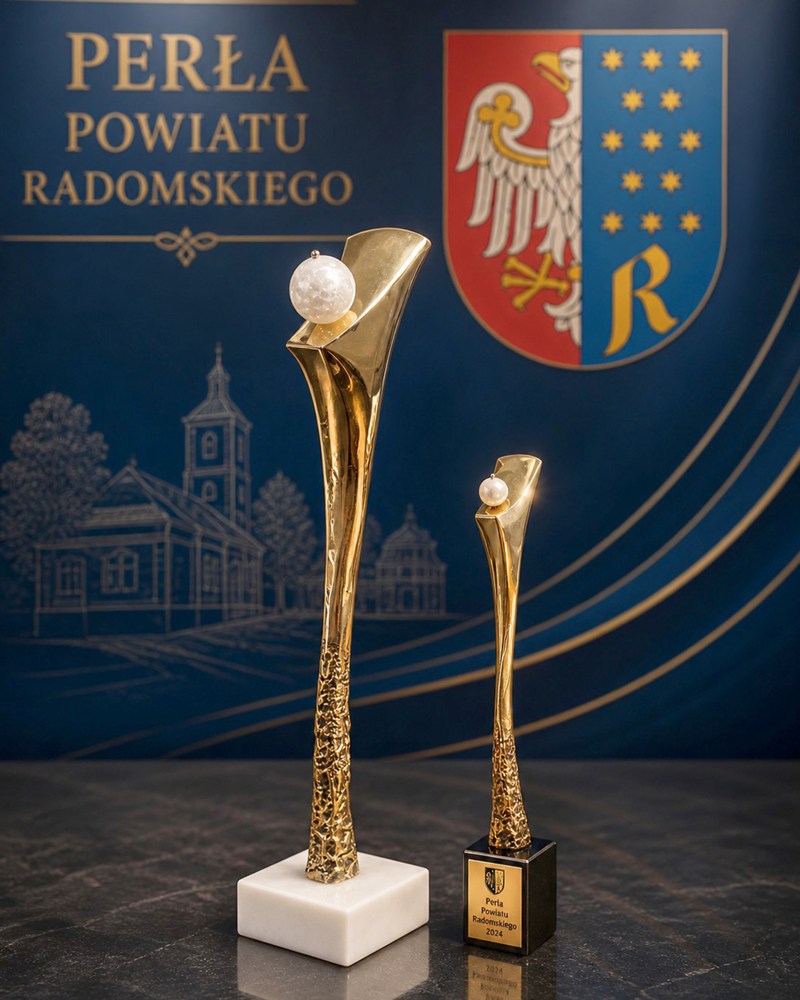 Statuetka „Perła Powiatu Radomskiego” zaprojektowana i wykonana przez Jerzego Stankiewicza. Symboliczna perła wieńcząca kompozycję podkreśla wyjątkową wartość, jakość i osiągnięcia laureatów Konkursu Gospodarczego Starosty Radomskiego.